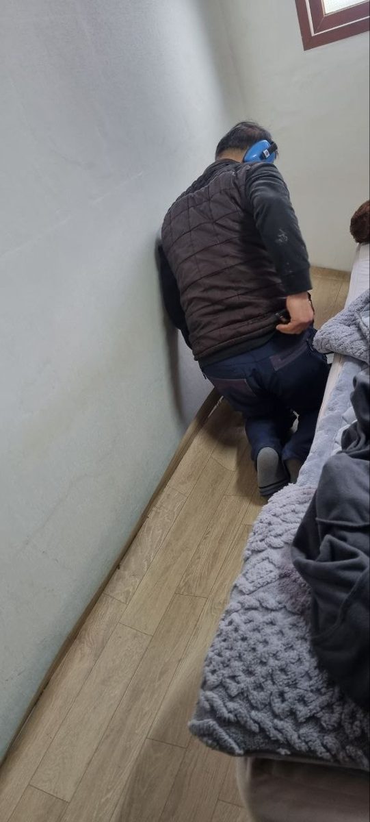 안방 벽과 바닥이 만나는 걸레받이 구간에 장비를 대고 벽체 안 배관을 확인하는 현장 사진